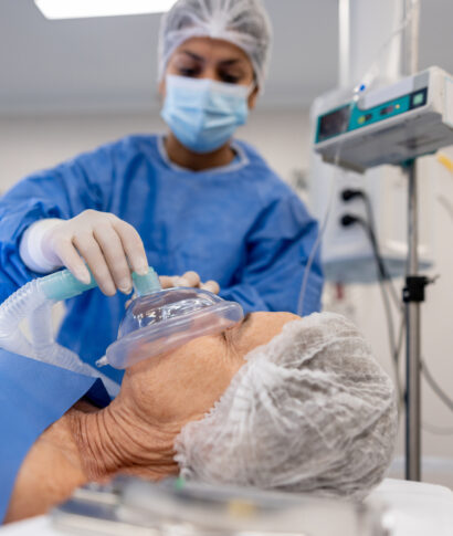 Doctor putting an oxygen mask on a patient under anesthesia at the hospital - operating room concepts